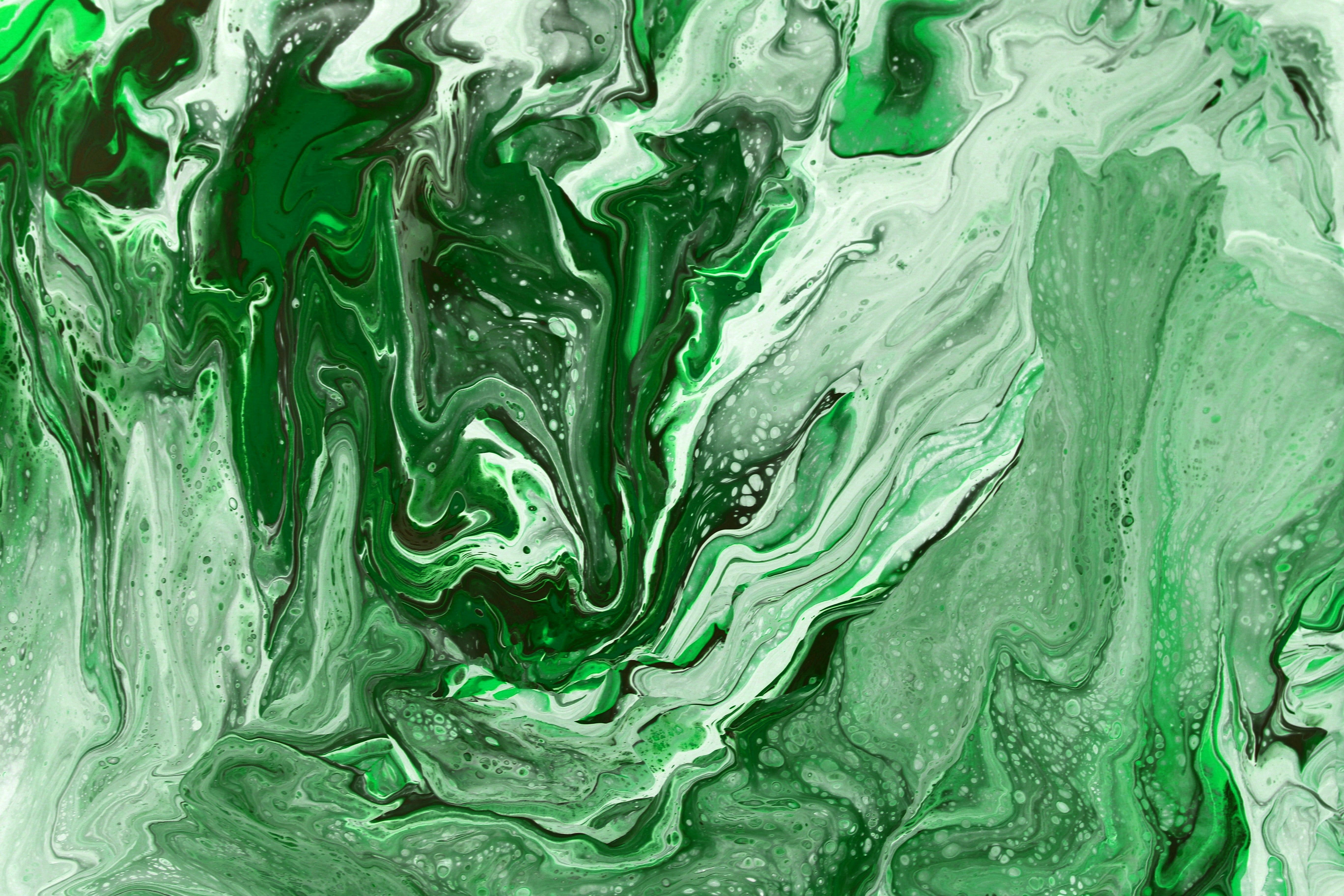 Dynamic abstract image with swirling green patterns and fluid art textures.