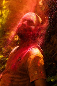 在户外拍摄的彩色肖像中，一个人身处粉末爆炸的瞬间，捕捉了生动的能量