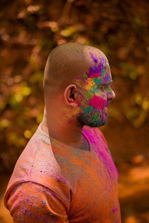 Free Profile portrait of a man with colorful face paint during Holi festival outdoors. Stock Photo