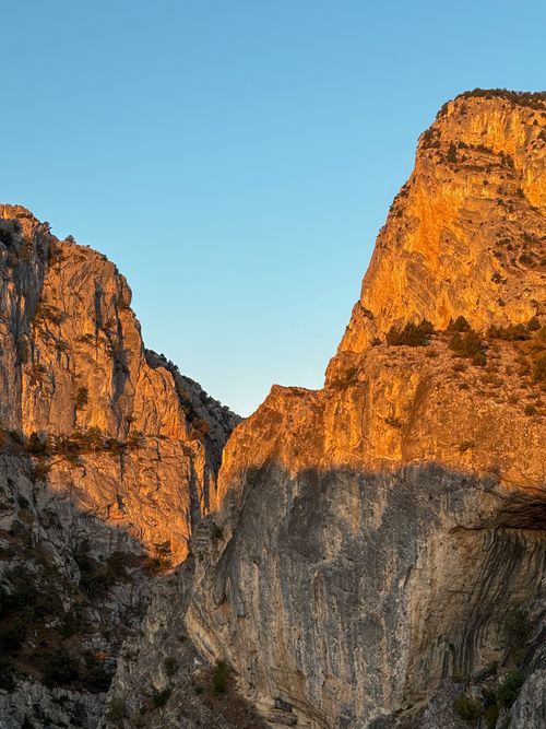 Free Golden light illuminates rugged mountain cliffs, capturing nature's drama at sunset. Stock Photo