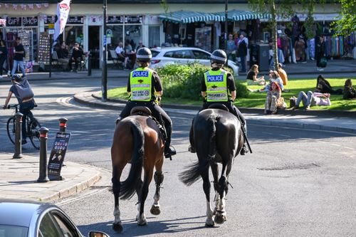 Free Two mounted police officers patrol a busy Oxford street, showcasing security presence. Stock Photo