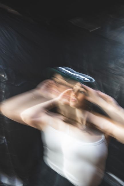 Abstract portrait of a woman in dynamic motion blur, creating a surreal studio effect.