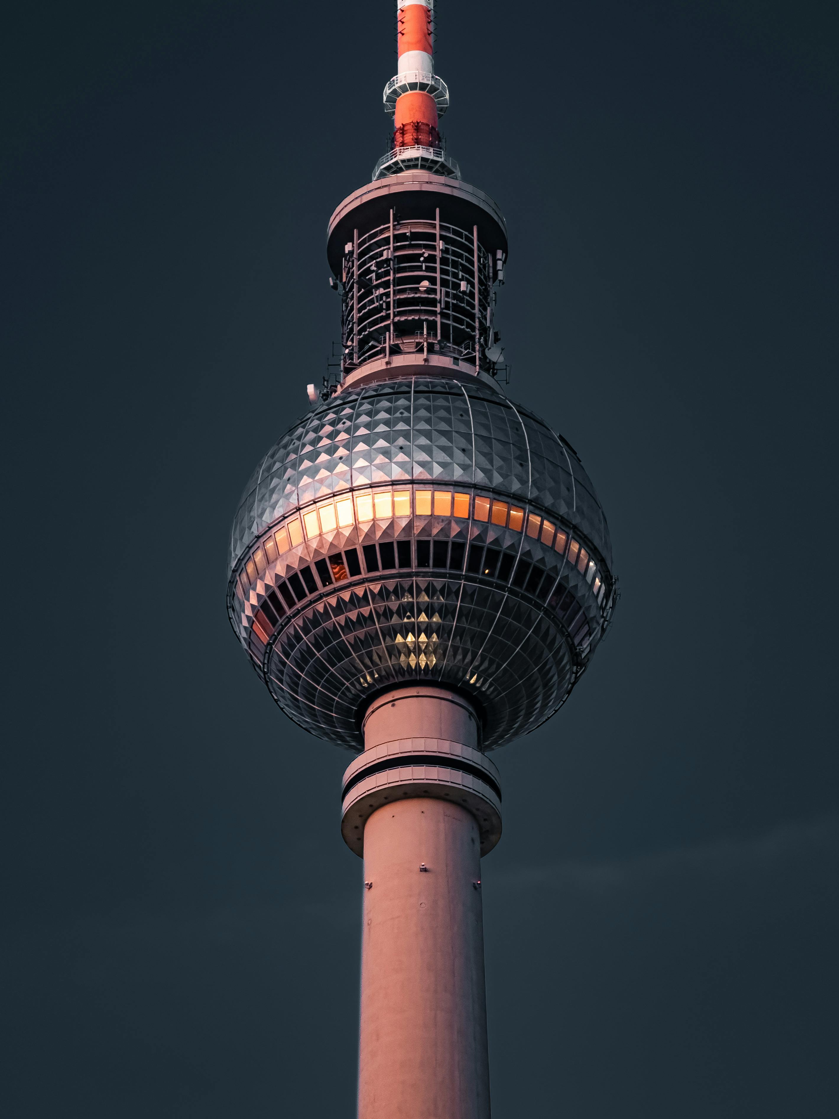 Close-up of the iconic Berlin TV Tower against a dark evening sky.