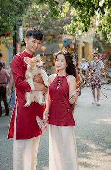 Young couple in traditional attire with a Corgi during Tet Festival in Hội An, Vietnam.