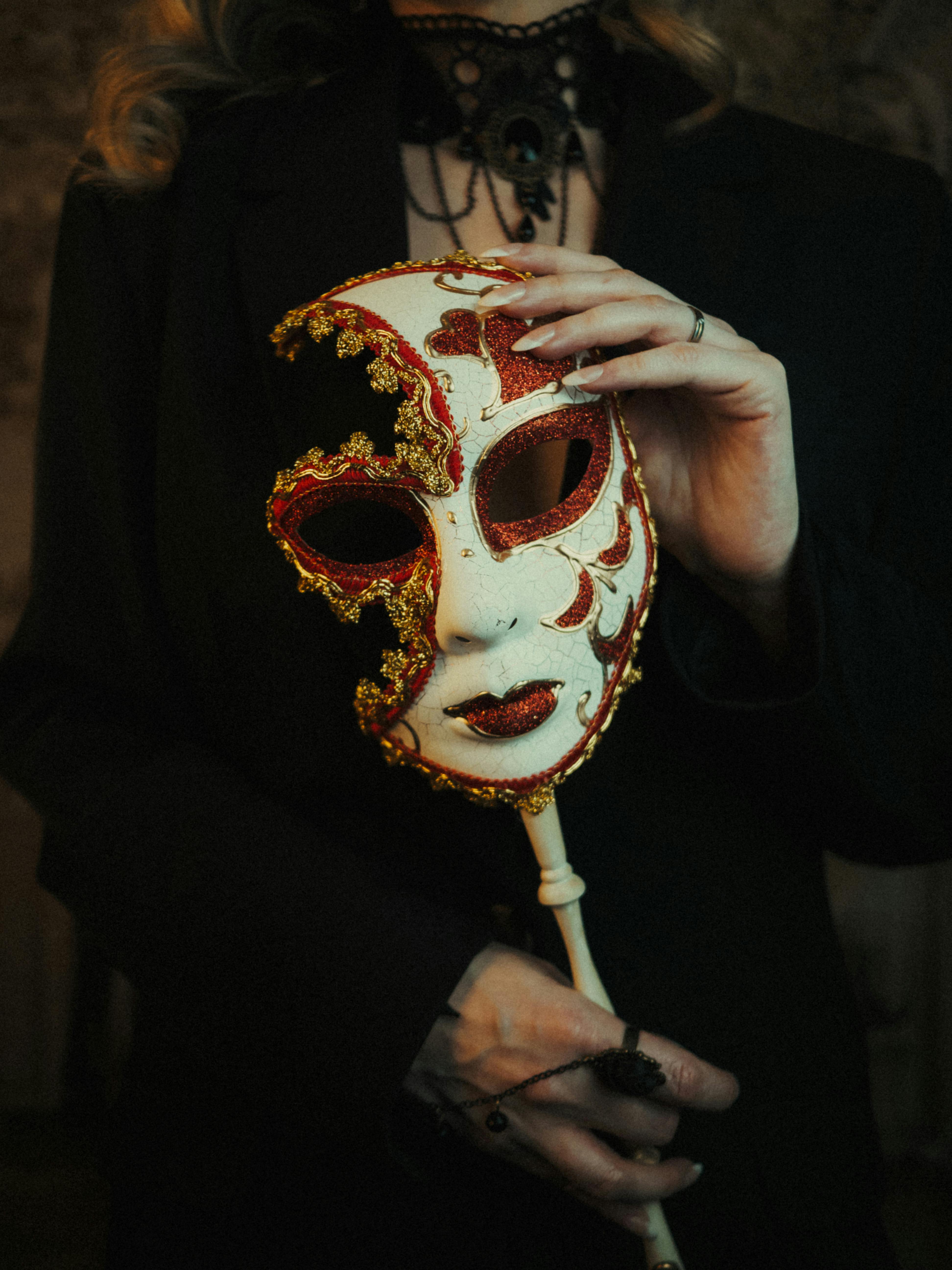 Gratis Nærbilde av en utsmykket venetiansk maske holdt av en kvinne i elegant antrekk. Arkivbilde