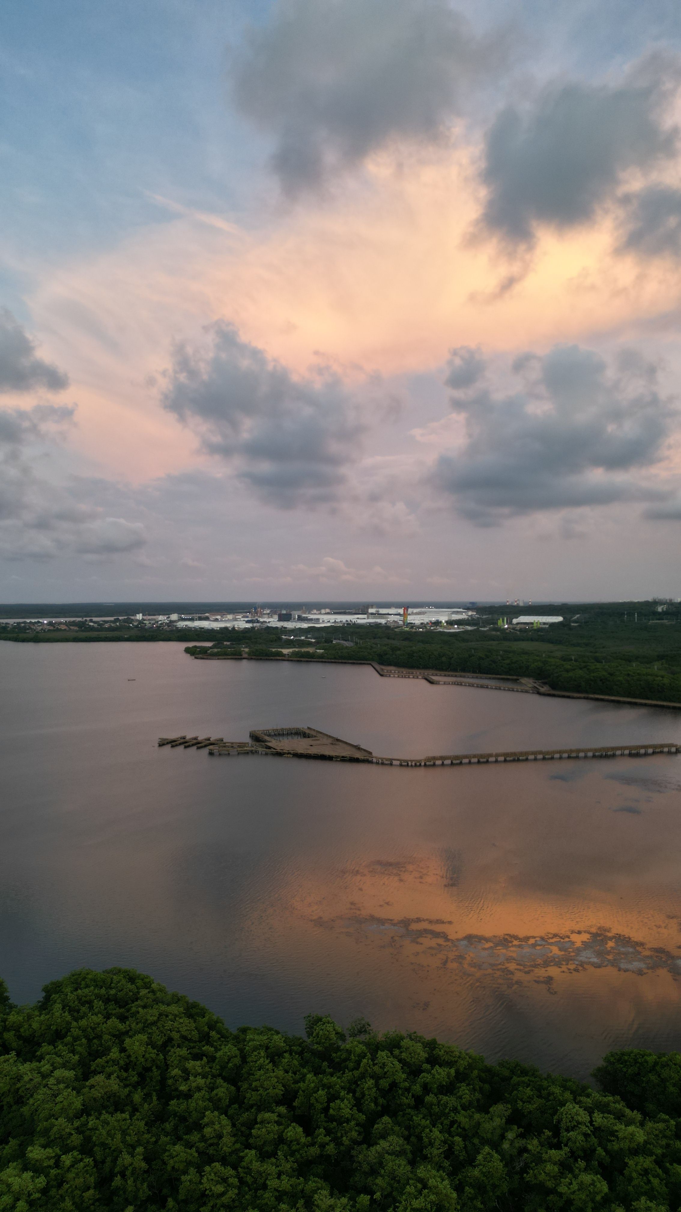 Fotomural Impresionante vista aérea de las marismas al atardecer en Atlántico, Colombia, que muestra cielos vibrantes y aguas tranquilas.