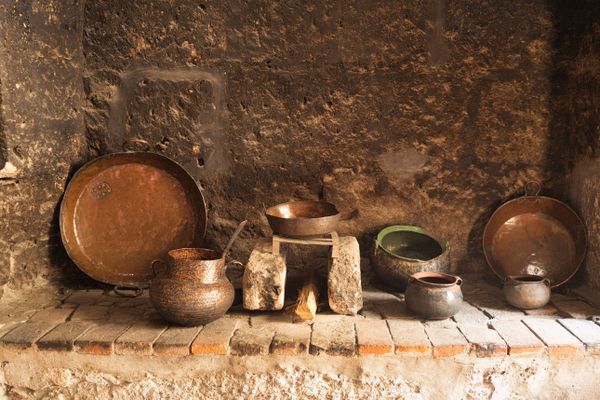 Copper pots on a stone hearth — photo by Fernando B M on Pexels
