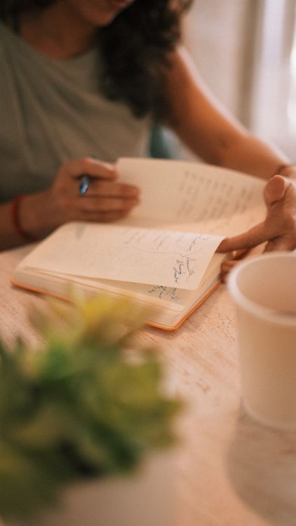 Person Writing in Notebook with Coffee Nearby · Free Stock Photo