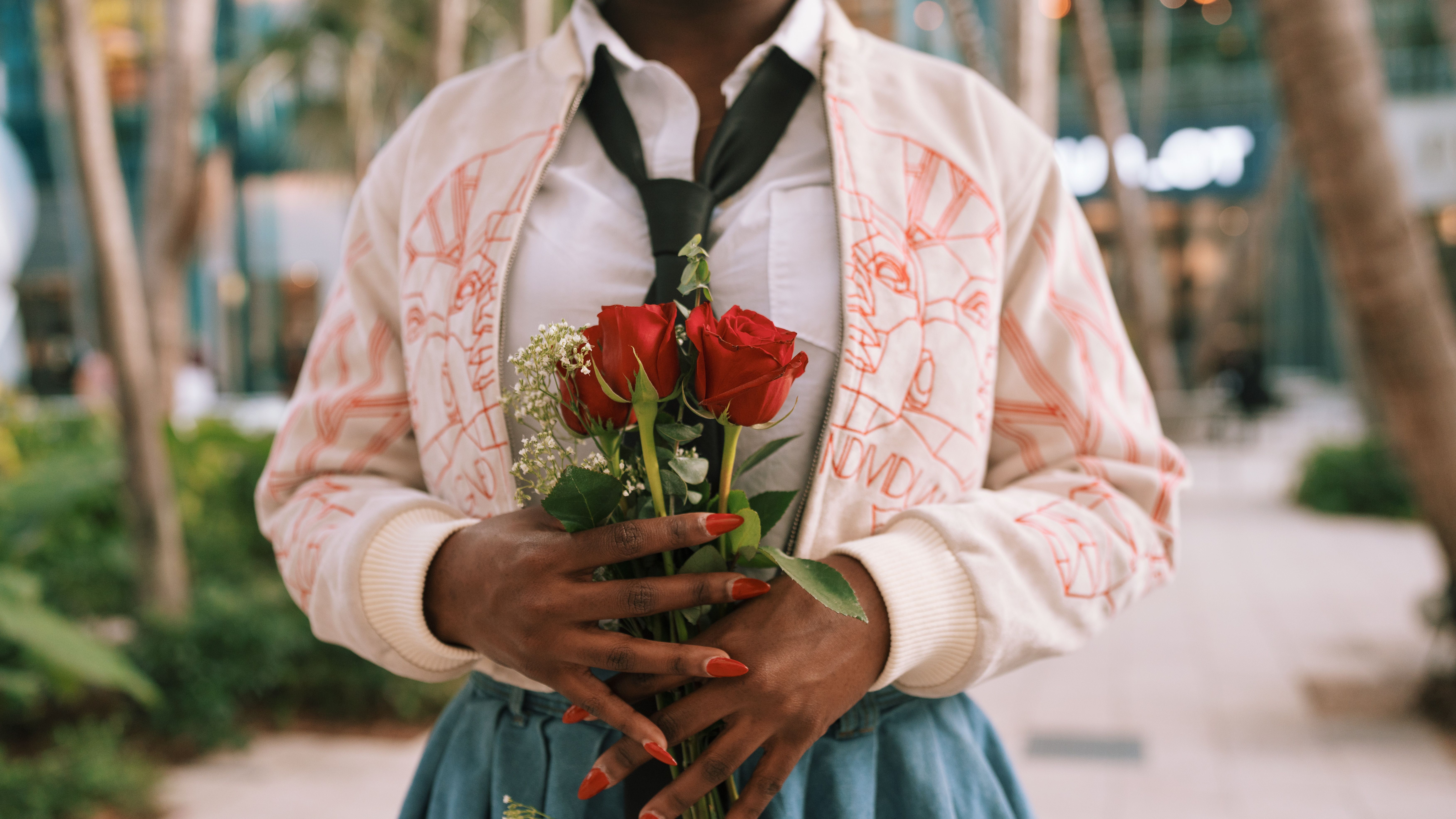 Person Holding Red Roses in Urban Setting · Free Stock Photo