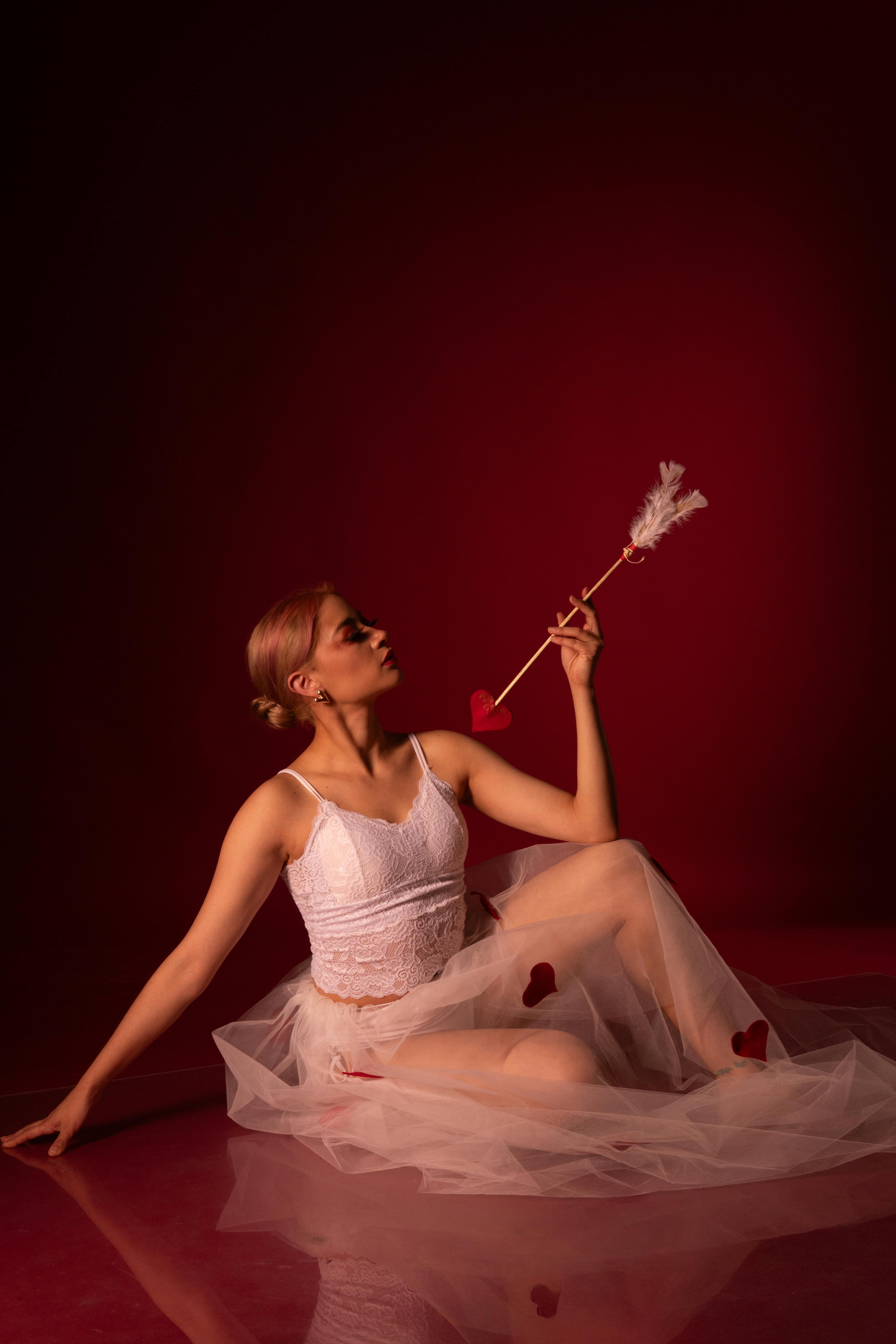 Ücretsiz Kırmızı arka planda aşk tanrısı temalı oklu bale dansçısı. Stok Fotoğraflar