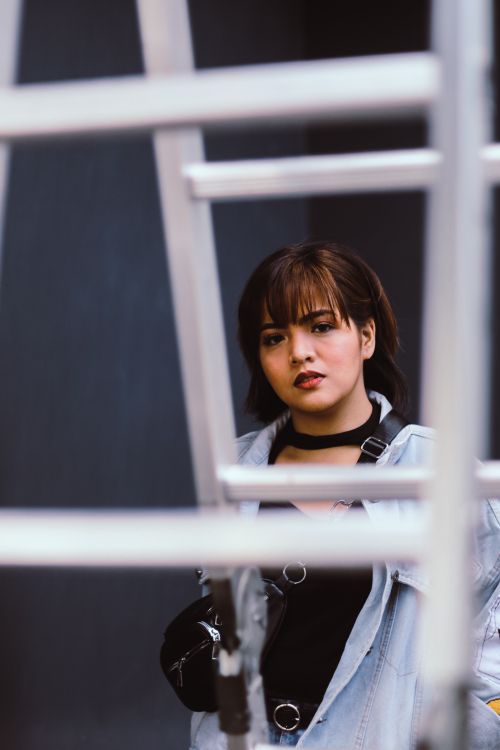 Free Portrait of a young woman in casual wear and short hair posing outdoors. Stock Photo