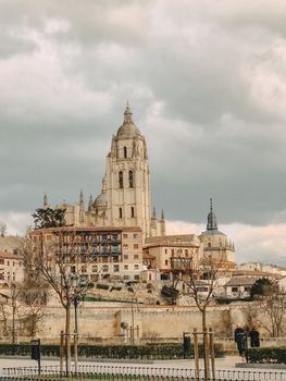 View of Segovia Cathedral under cloudy skies, capturing its detailed architecture.