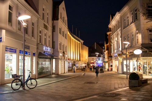Free Night view of a vibrant street in Hamburg with illuminated buildings and people strolling. Stock Photo