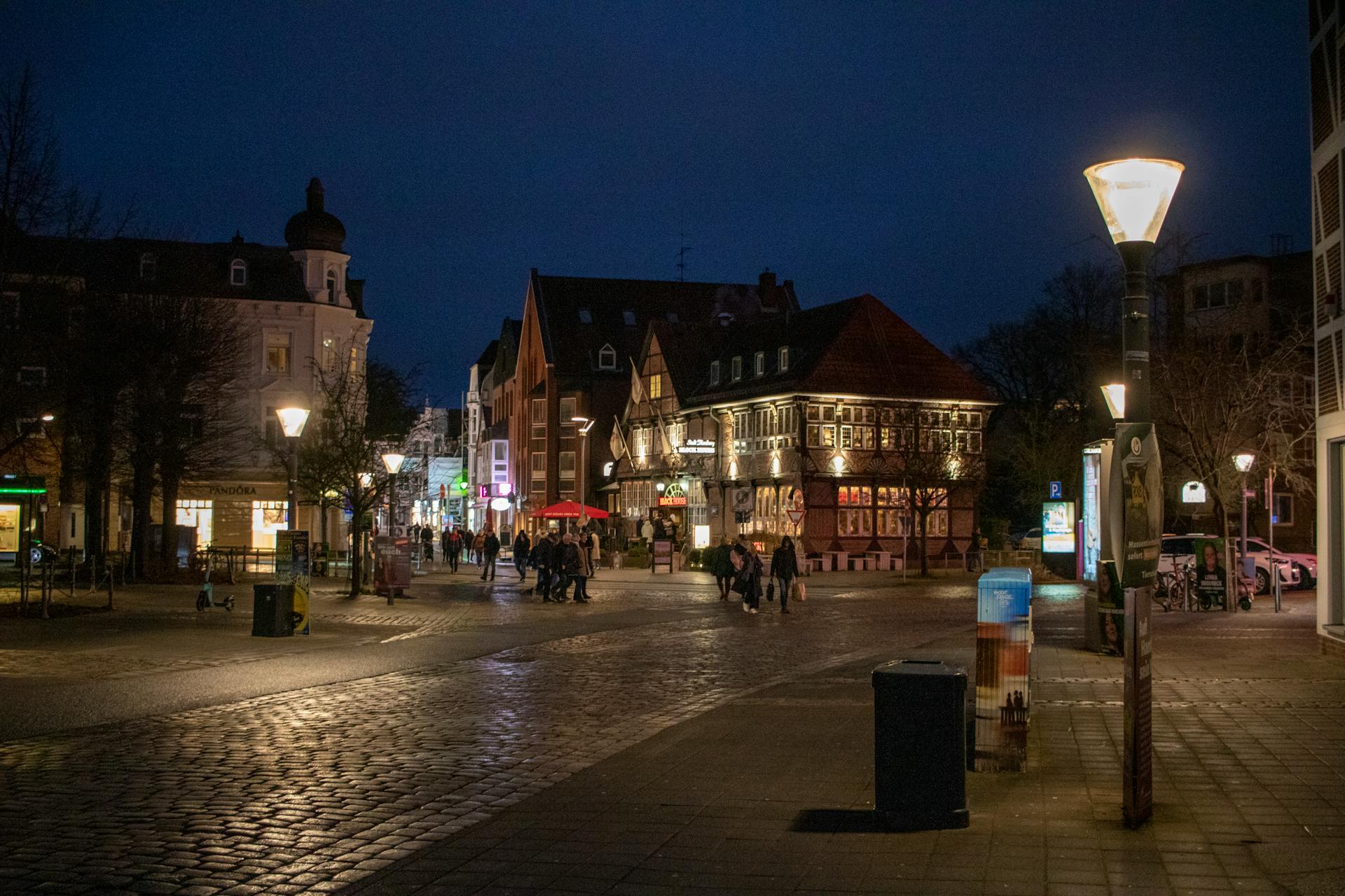 Nighttime street view in Hamburg, showcasing historic architecture and street lamps.