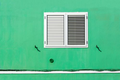Free Simple yet striking green wall with white shutters creating a bold minimalist look. Stock Photo