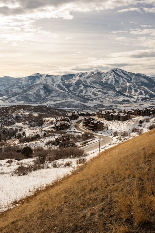 Free Scenic view of a snow-covered mountain landscape in Utah with rustic houses below. Stock Photo