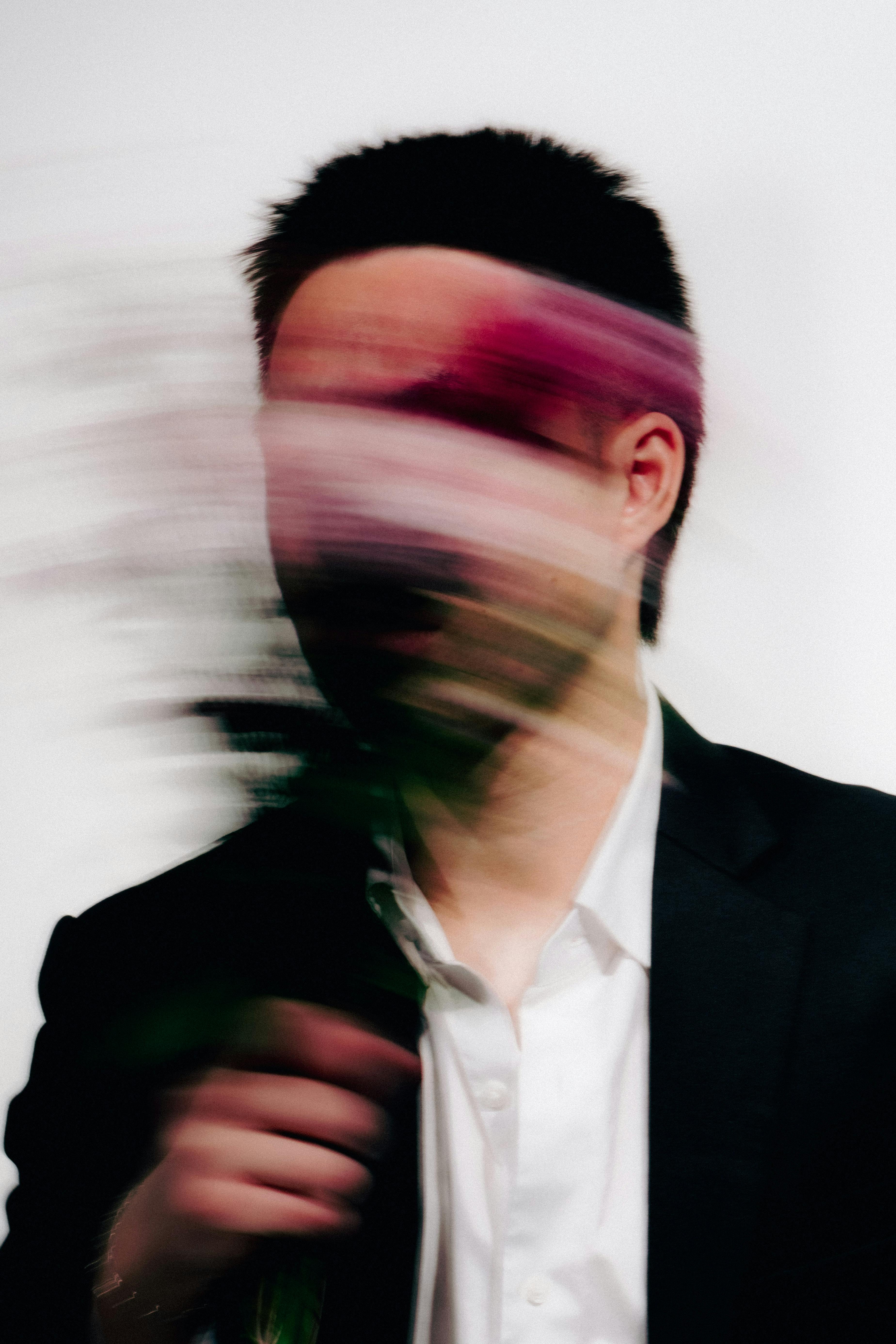 A creative studio portrait of a man with blurred floral bouquet, emphasizing motion.