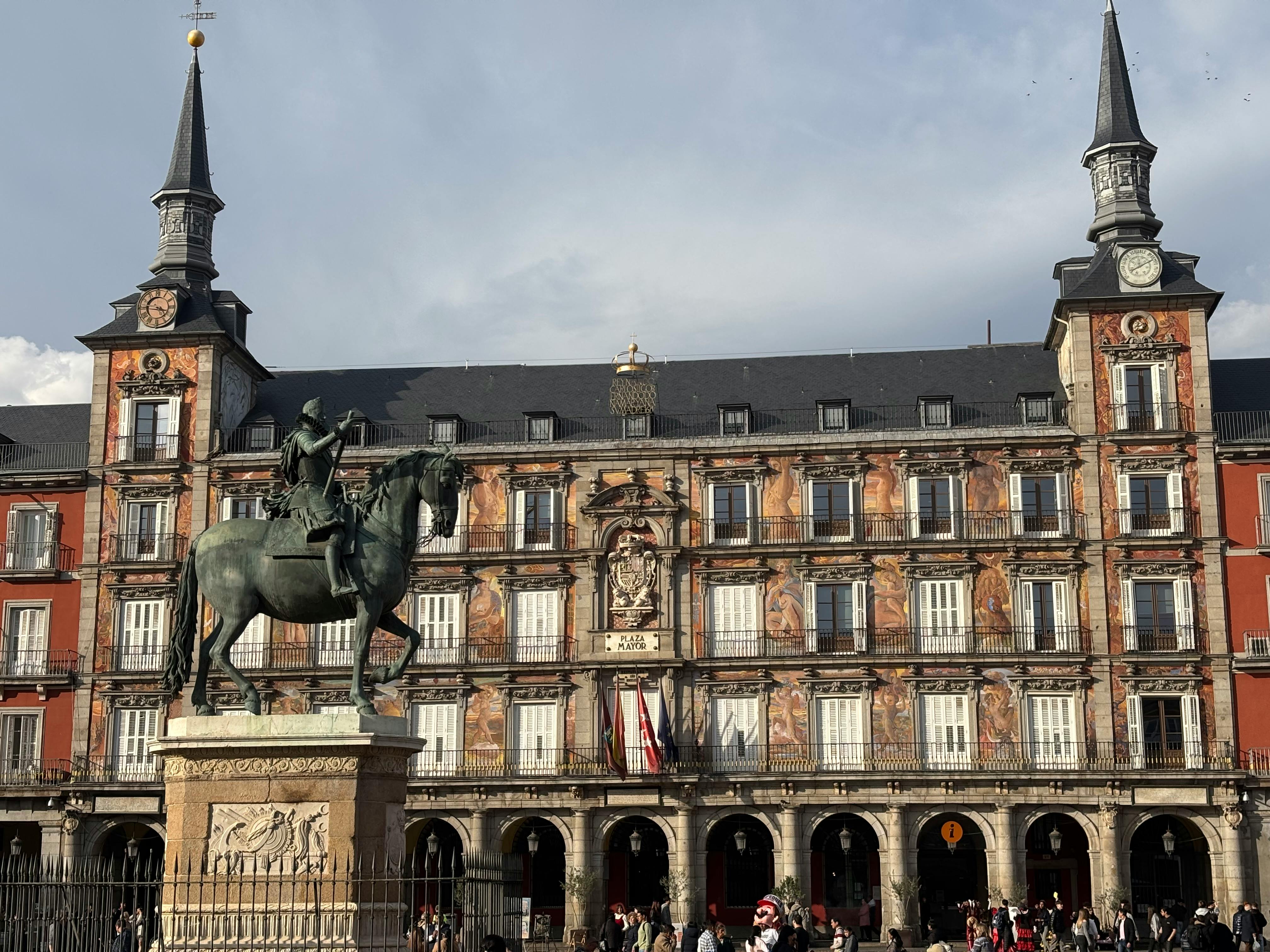 Equestrian statue and arcaded facades at Plaza Mayor in Madrid.