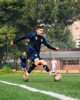 A soccer player skillfully dribbles the ball during a match on an outdoor field.