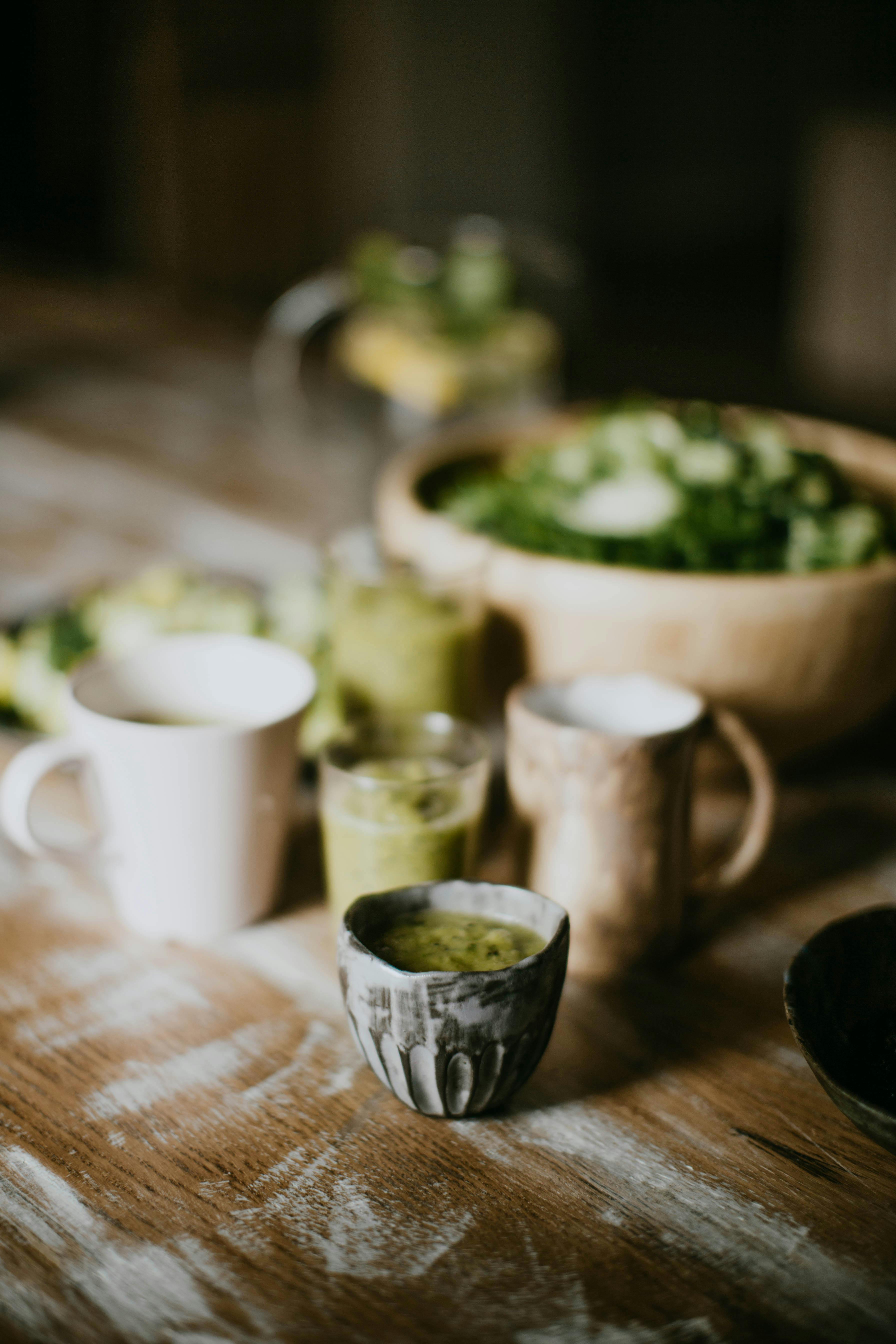 乡村木桌上，早晨的冰沙、咖啡杯和沙拉构成了一幅诱人的场景