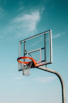 A basketball hoop outdoors against a clear blue sky, perfect for sports themes.