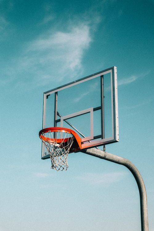 Free A basketball hoop outdoors against a clear blue sky, perfect for sports themes. Stock Photo
