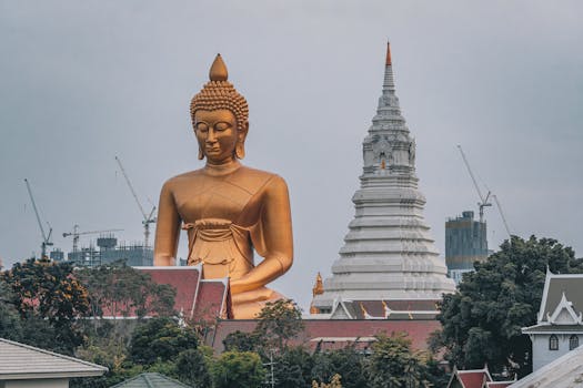 Majestic golden Buddha statue beside a temple in Bangkok, Thailand