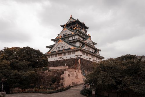 Free Capture the grandeur of Osaka Castle surrounded by lush greenery on a cloudy day. Stock Photo