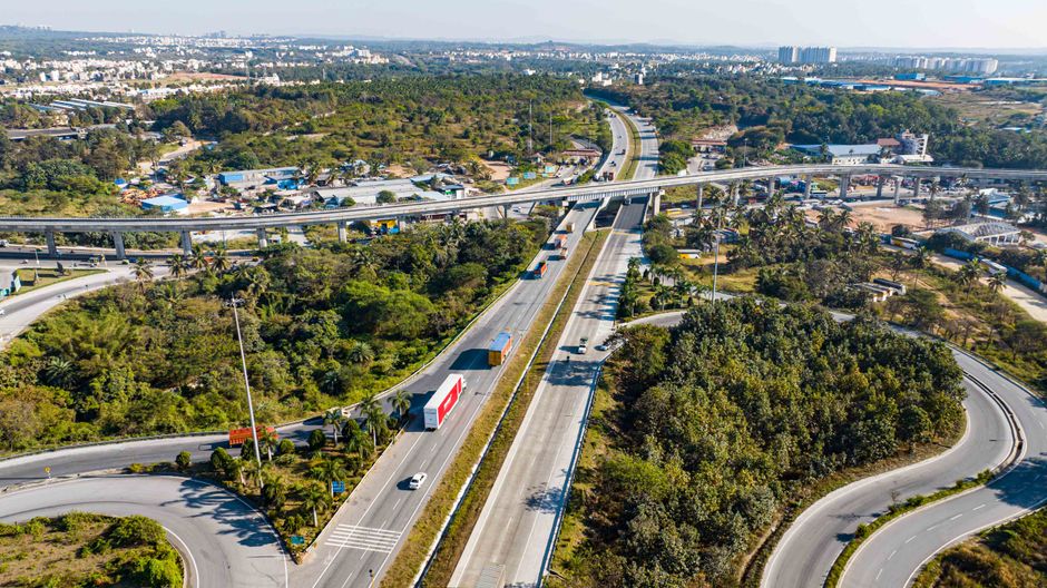 Highway interchange with vehicles in a city from an aerial perspective.