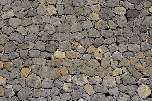 Close-up of an irregular textured stone wall with a natural rustic appearance.