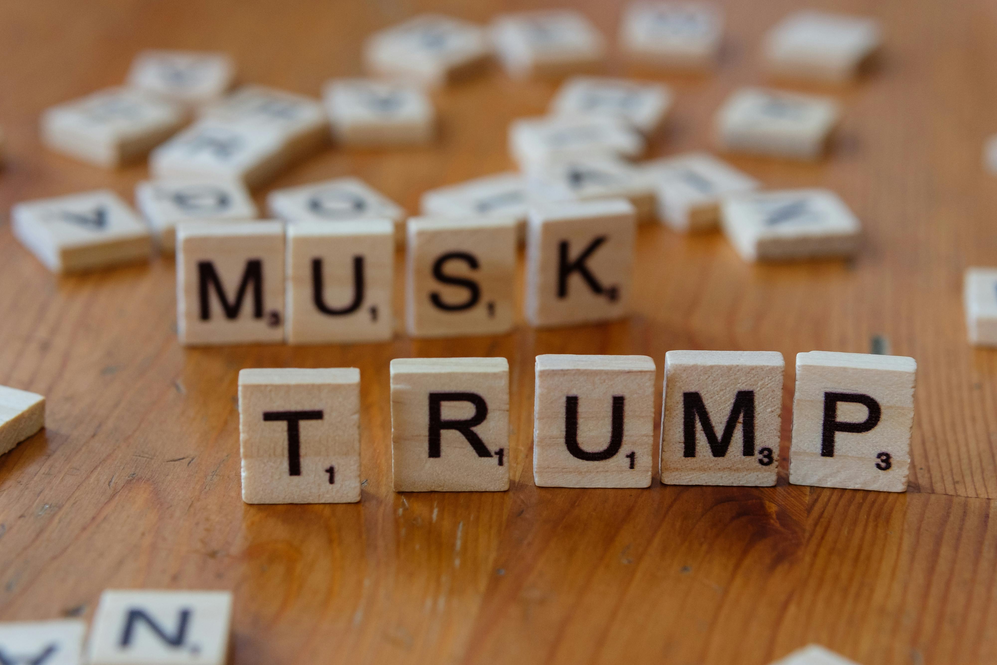 scrabble tiles spelling musk and trump on wooden surface