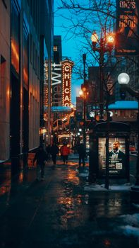 A lively evening street scene in downtown Chicago with iconic Chicago Theater marquee lighting up the night.