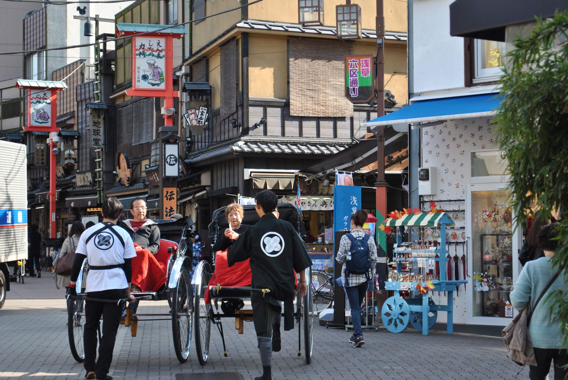 Vibrant street scene with traditional rickshaws and bustling shops in a lively marketplace.