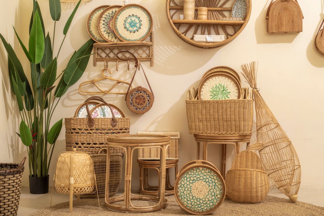 Bamboo shelving unit with books, plants and ceramic objects in natural home