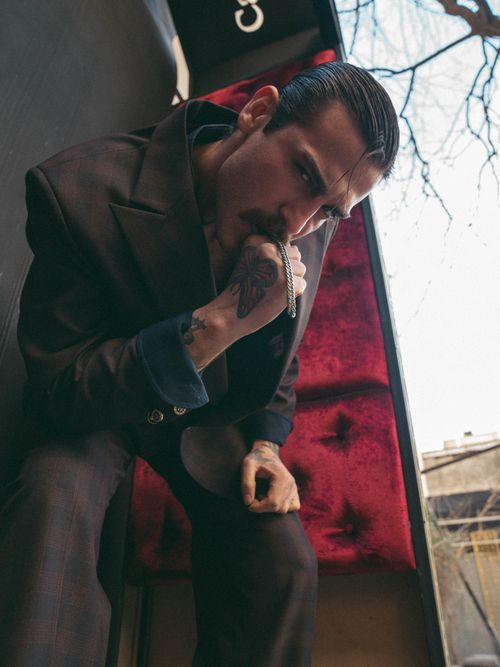 Free Young man with tattoos posing in a stylish suit outdoors, displaying a cool and confident look. Stock Photo