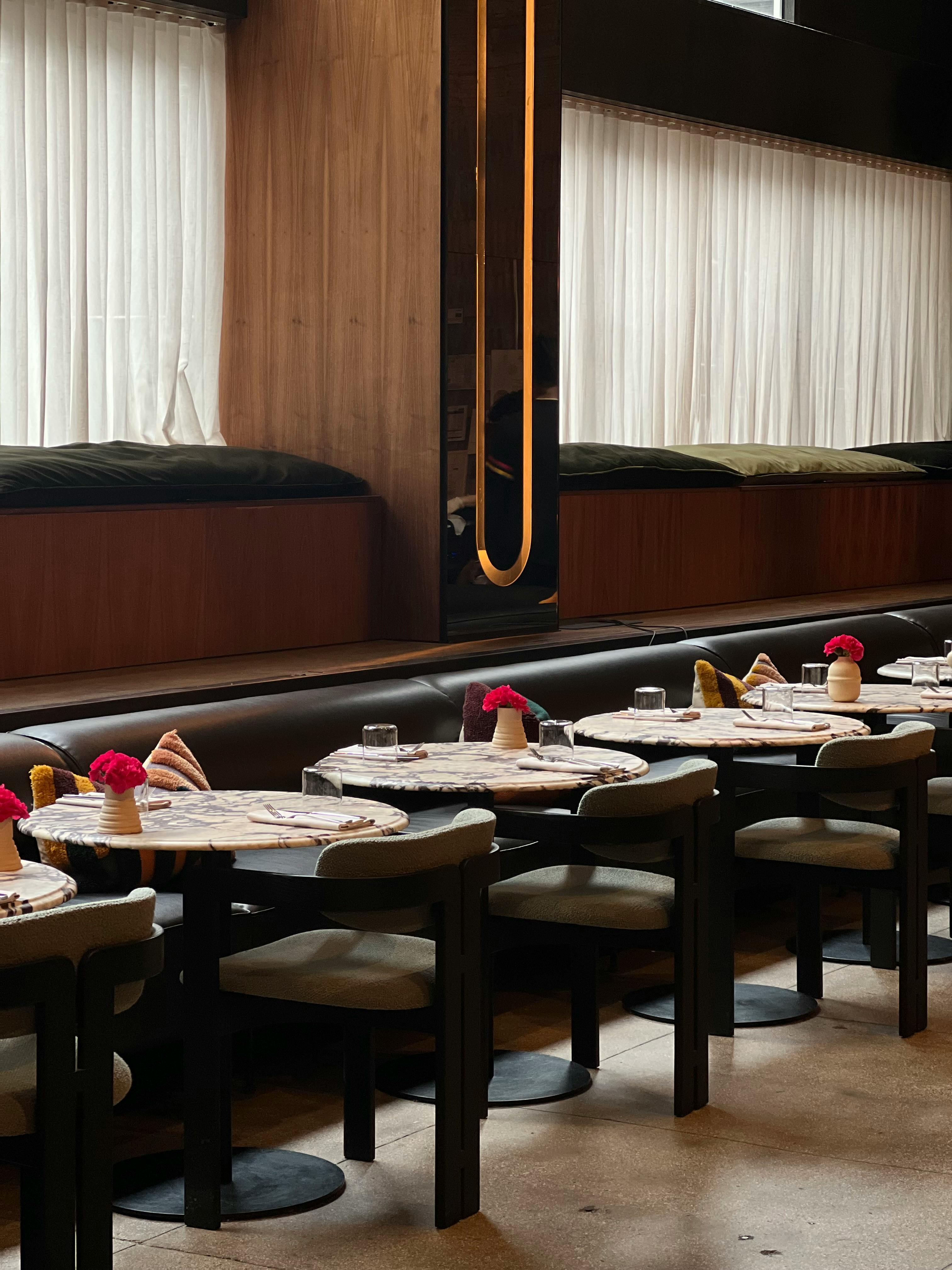 Salle de restaurant moderne avec tables dressées et lumière chaude