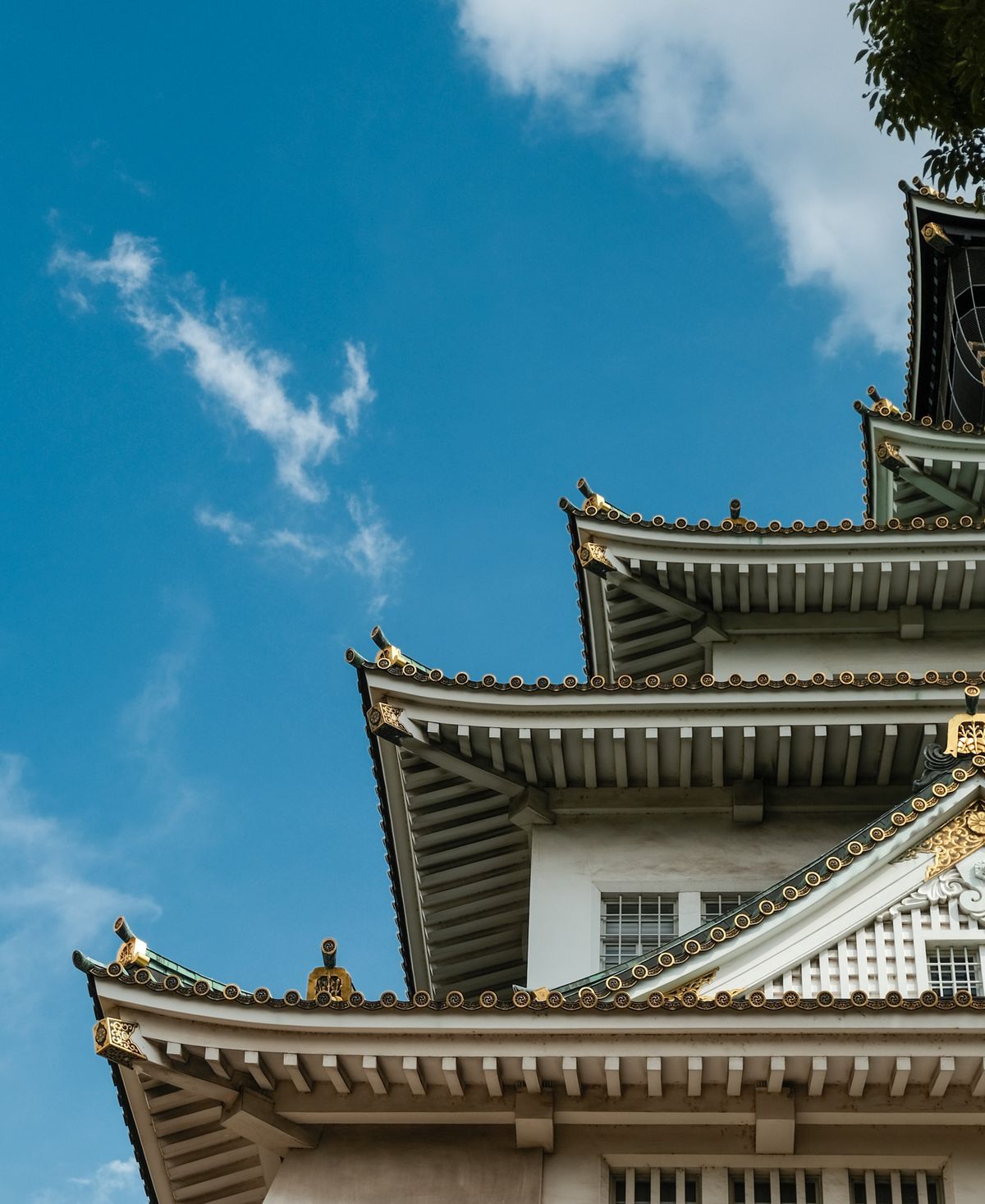 Traditional Japanese castle roof against a clear blue sky in western Japan