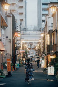 A person strolls down a lively city street lined with glowing signs and lanterns, creating a warm urban atmosphere.
