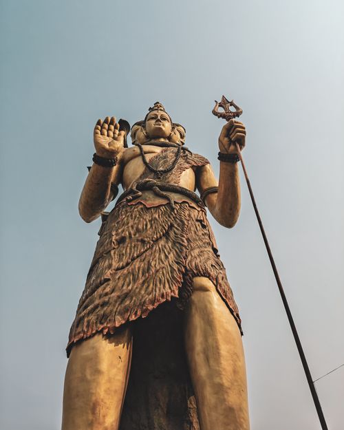 Free Dramatic low-angle view of a large Lord Shiva statue against a clear sky. Stock Photo