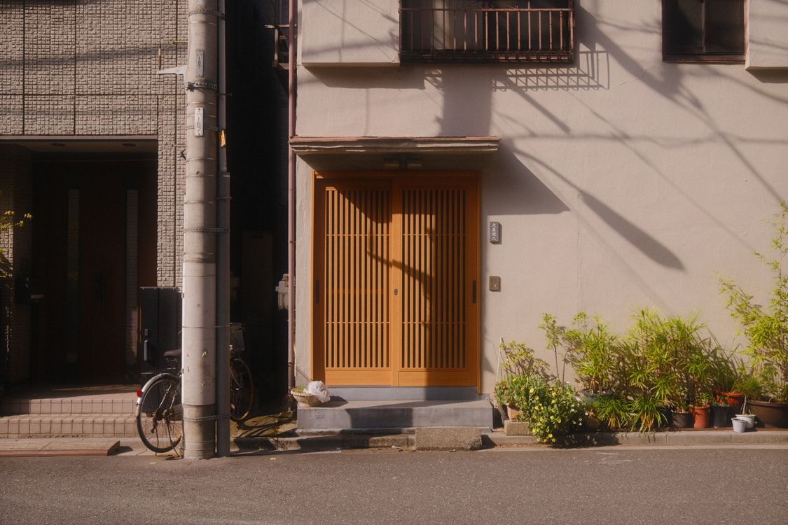 Traditional Japanese house entrance with wooden lattice doors on a quiet Tokyo street