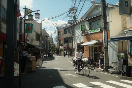 Busy street in Tokyo, Japan, showcasing daily life with bicycles and pedestrians under clear skies.