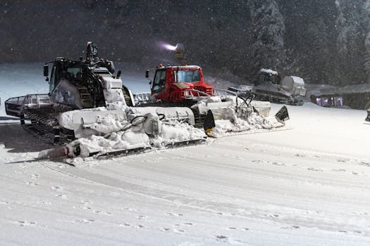 Night scene of snowcats grooming a snowy slope, enhancing winter sports terrain.