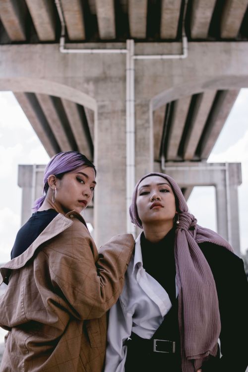Free Stylish women posing confidently in urban fashion under a bridge. Stock Photo