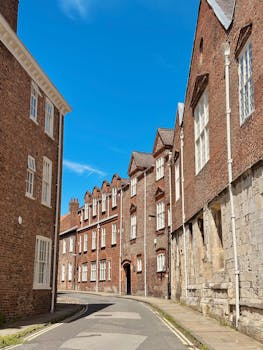 Captured on a sunny day, this classic York street scene features historic brick architecture under a vibrant blue sky.