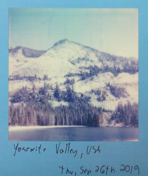 A charming vintage polaroid capturing Yosemite Valley's serene landscape and snowy mountain peaks.