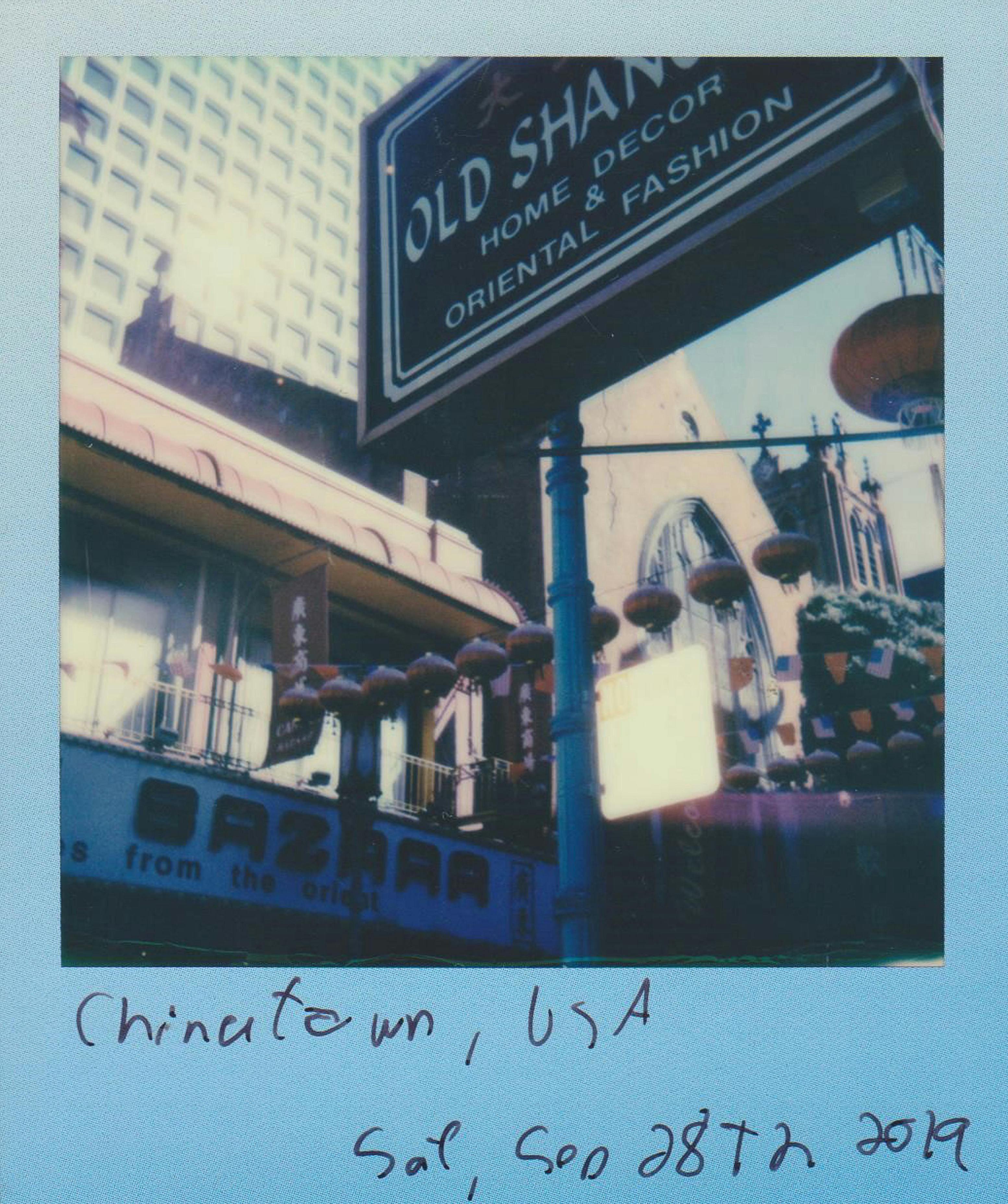 A retro Polaroid photo capturing a vibrant Chinatown street with signage.