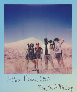 一张四个成年人探索美国凯尔索沙丘的复古照片