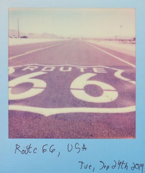 在晴朗的天空下，复古宝丽来捕捉了66号公路的标志性符号