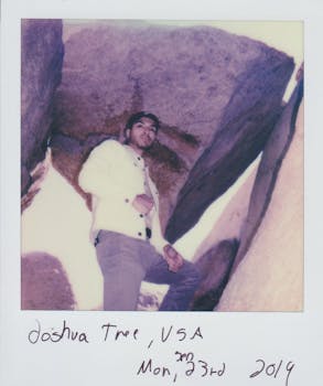 一张怀旧的即时照片中，一名男子在美国约书亚树的岩石间摆着姿势