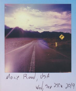 一张复古风格的宝丽来照片，拍摄于美国莫哈韦路，背景是风景优美的日落